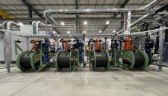 Inside a factory, several large machines are visible, highlighting the machinery used in manufacturing processes.