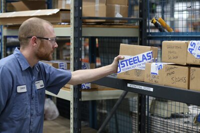 Warehouse worker picking up box from shelf