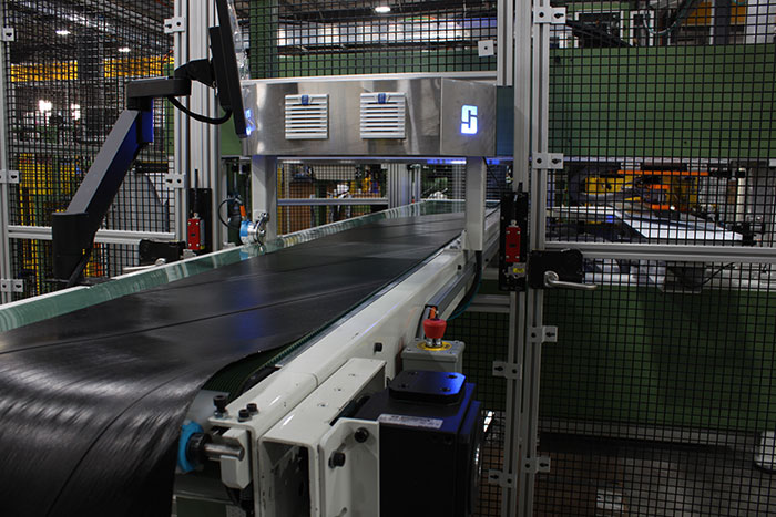 STEELASTIC® Extruded Steel Belt System showing the belt moving through the machine